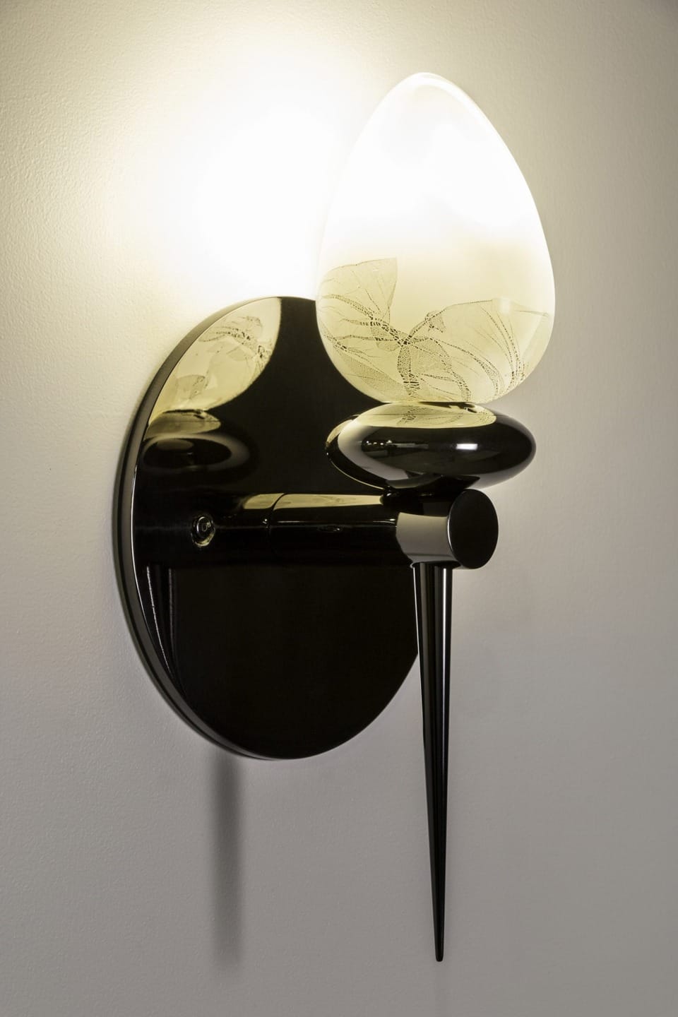 Modern wall sconce with a frosted glass shade and black metal base, mounted on a light-colored wall.