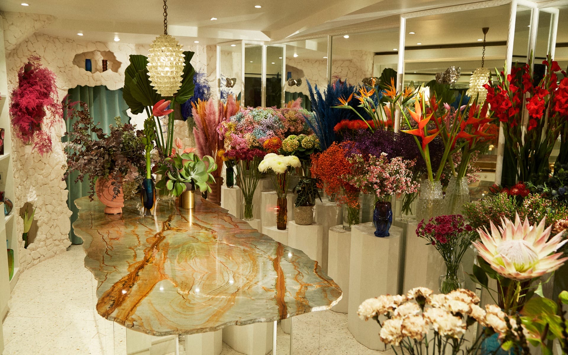 Luxurious floral shop interior with vibrant flower arrangements and a marble table centerpiece.