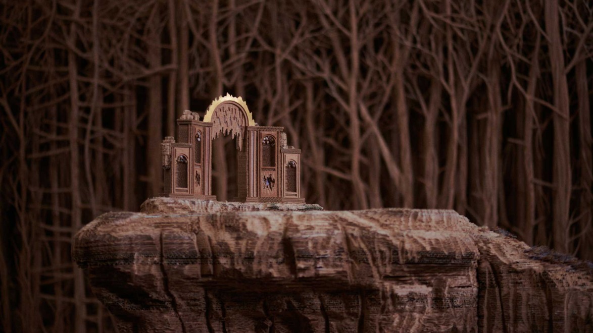 Miniature castle structure on a rocky cliff, surrounded by detailed dark, barren trees in a mysterious forest setting.