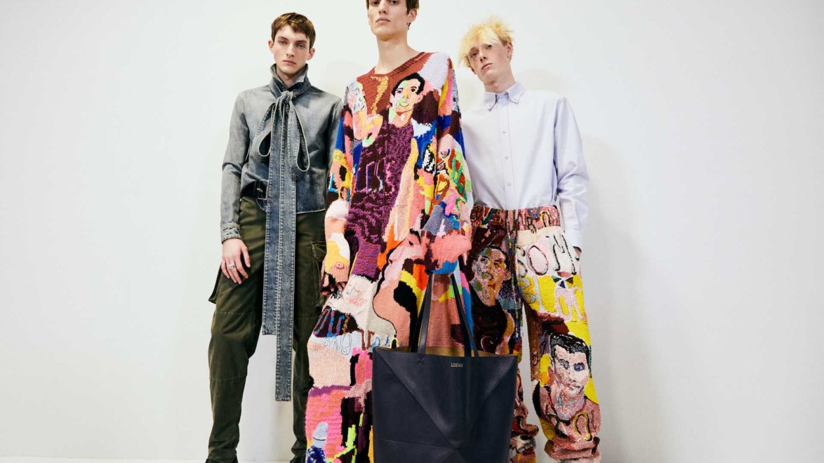 Three models wearing colorful, artistic outfits in a studio setting, showcasing modern fashion designs.