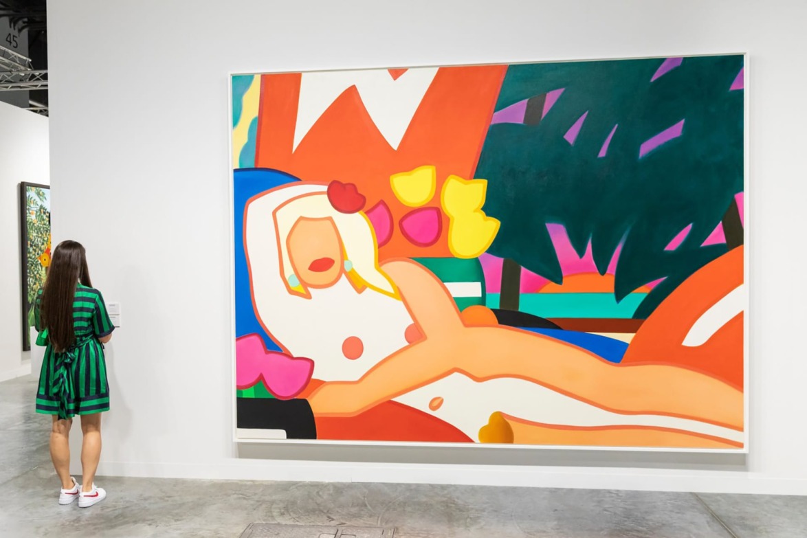 Woman viewing colorful abstract painting of a reclining figure in a gallery setting.