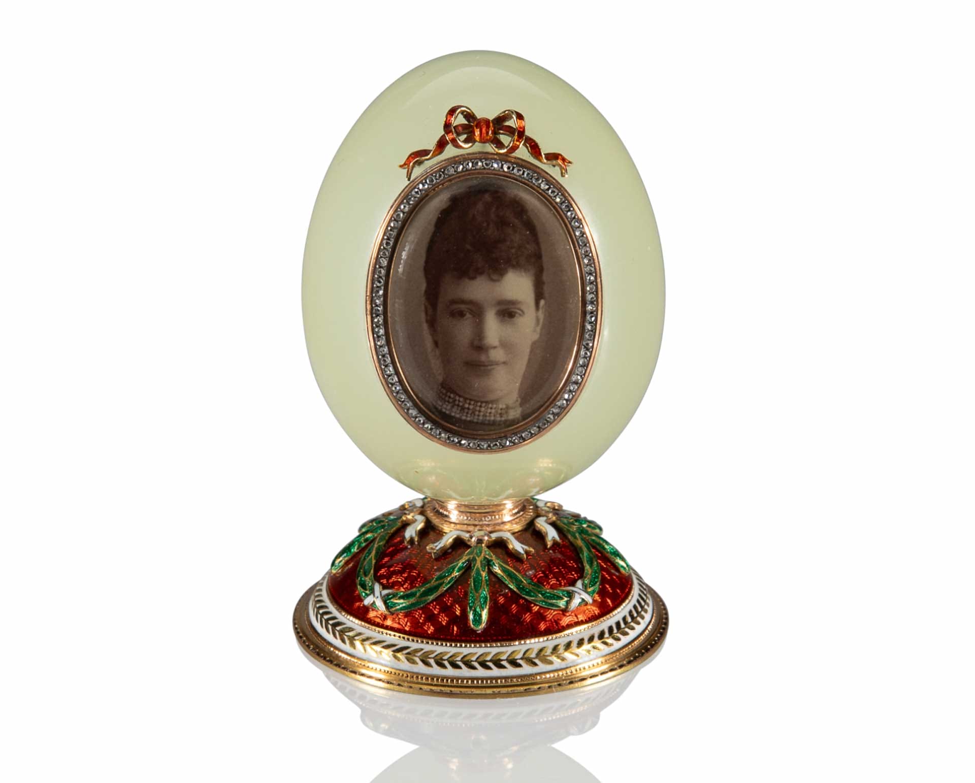 Bejeweled Fabergé egg with a vintage black and white portrait of a woman, ornate red and green base