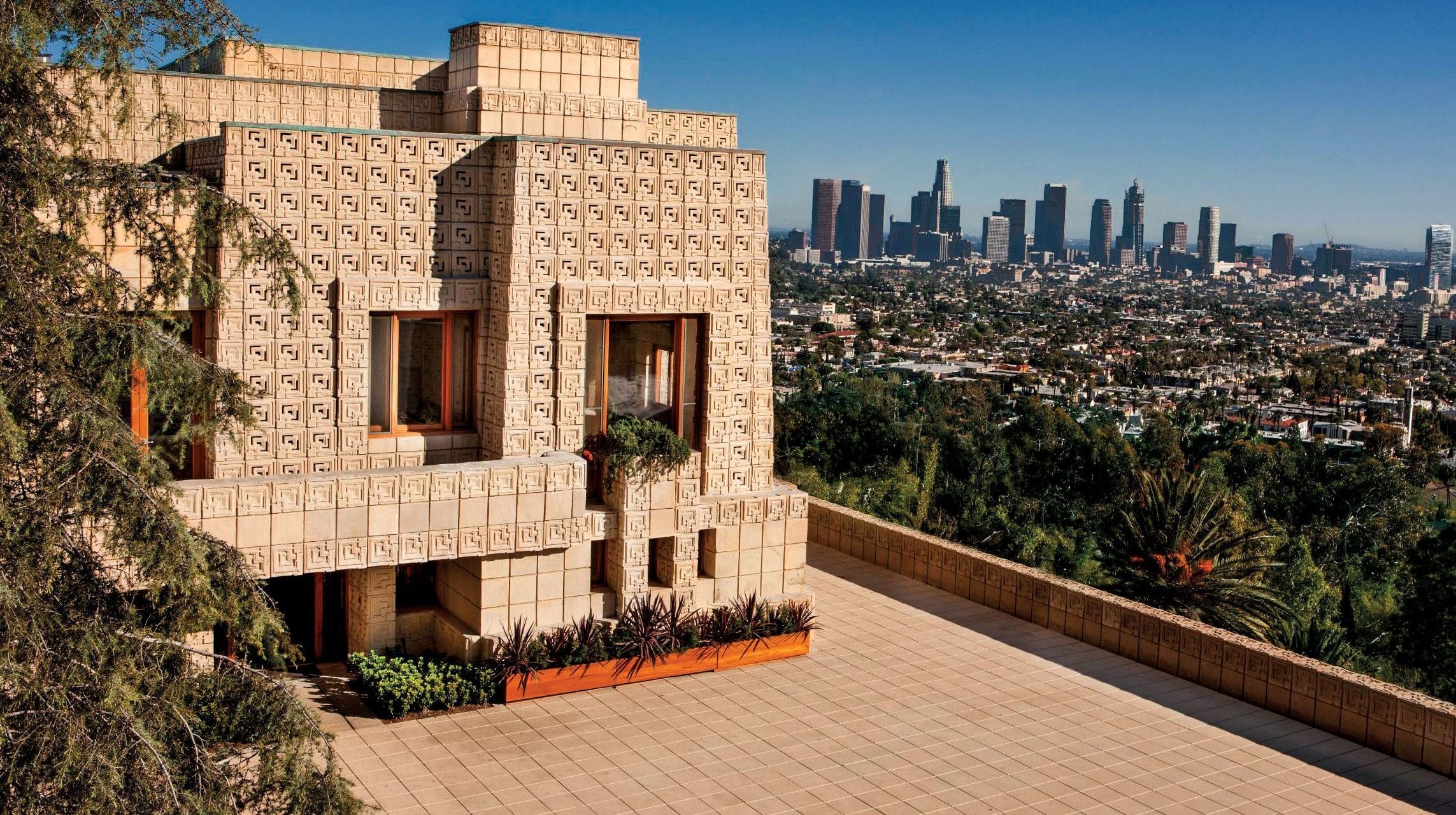 Architectural modern home with intricate geometric design overlooking a city skyline in the background.