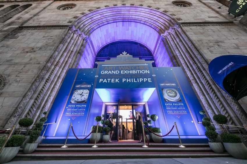 Entrance to the Patek Philippe Art Watches Grand Exhibition with a blue-lit archway and red ropes.