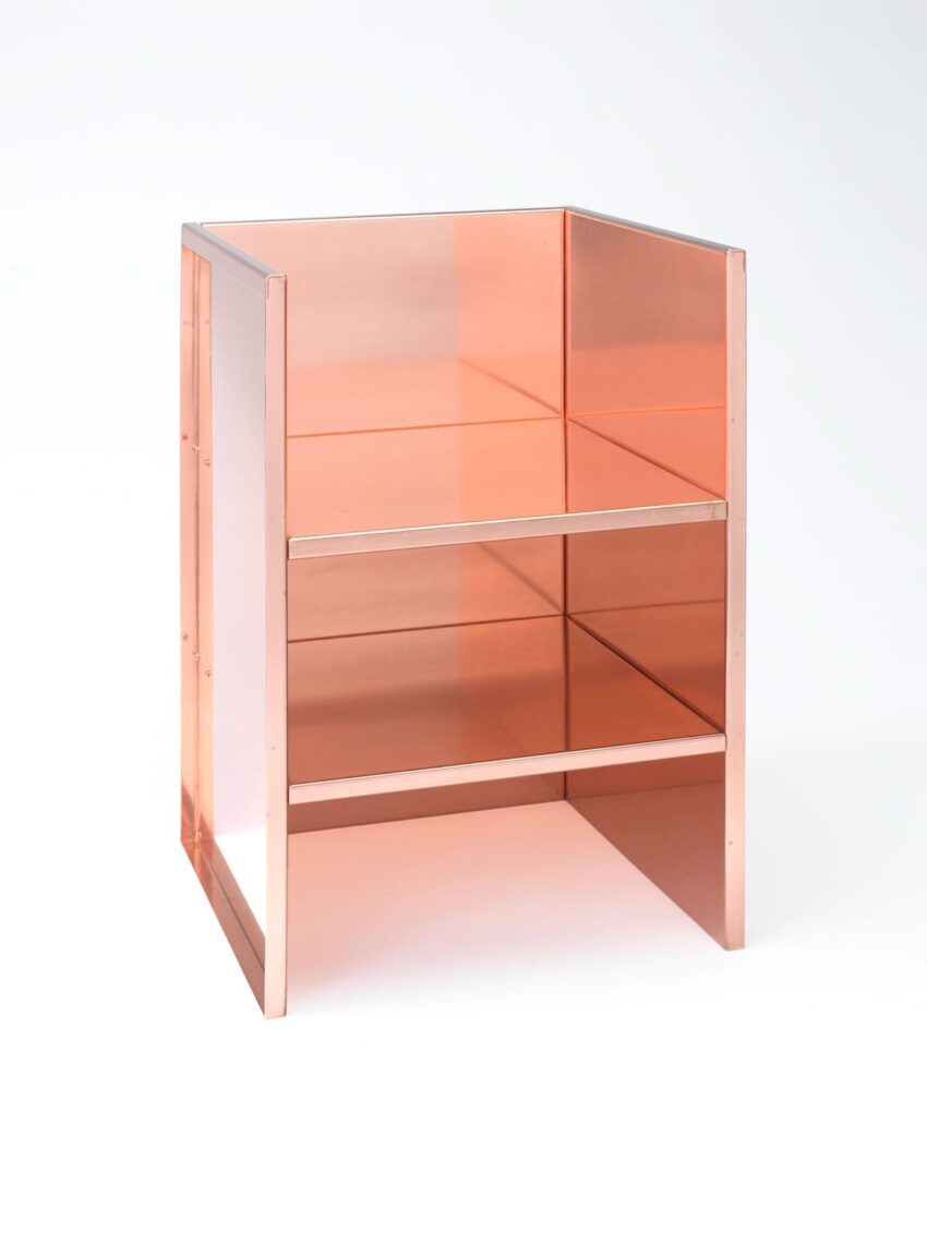 Modern transparent orange chair with a geometric design and two tiered shelves against a plain white background.