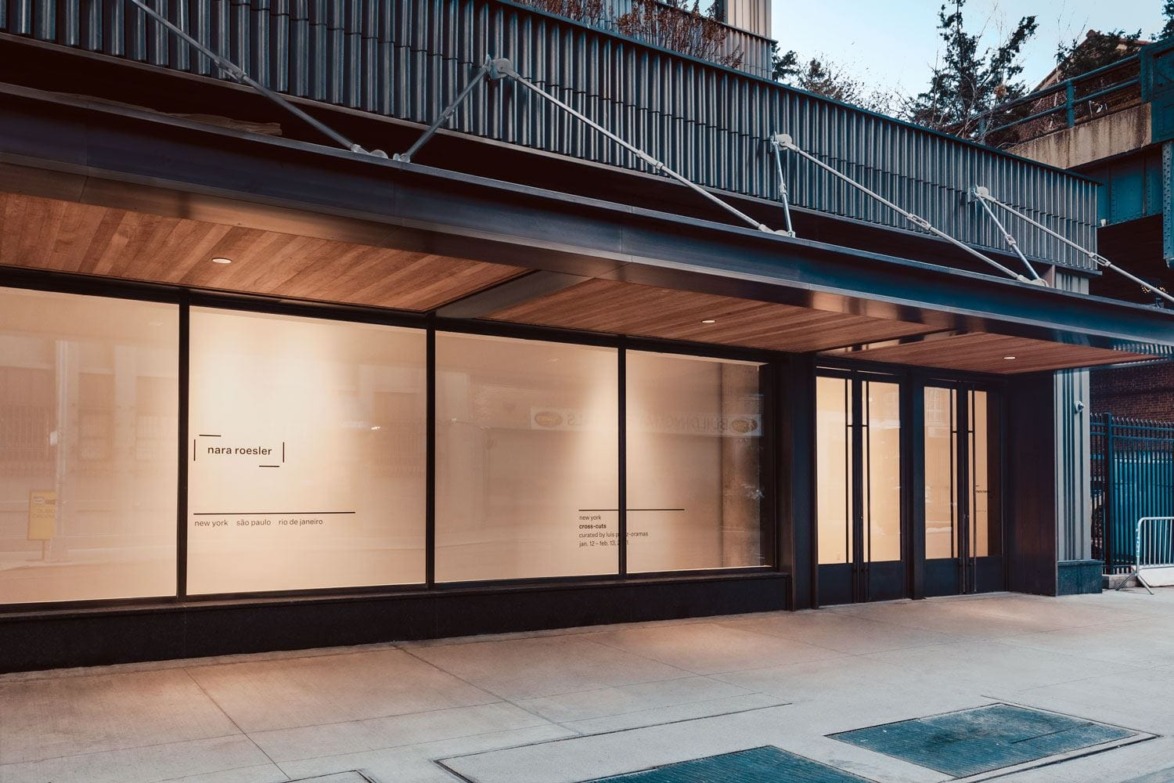 Art gallery exterior with large windows and modern design on a street corner.