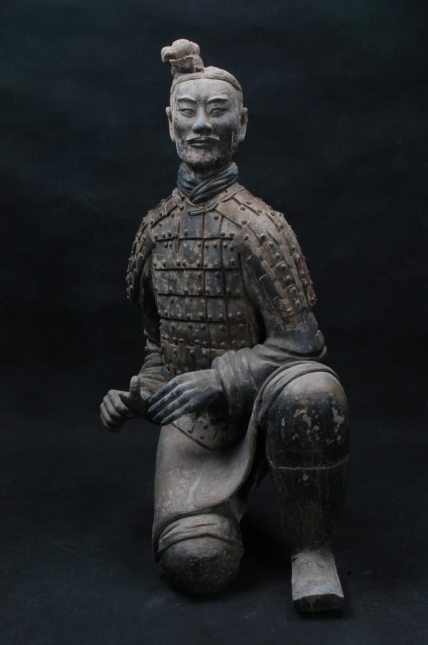 Kneeling Terracotta Warrior statue with intricate armor, part of the ancient Chinese Terracotta Army exhibition.