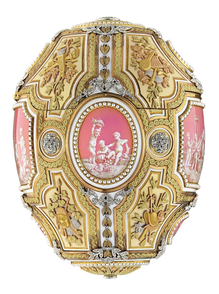 Ornate decorative artwork with gold detailing, pink accents, and intricate carvings featuring classical figures.