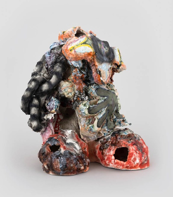 Abstract colorful ceramic sculpture with textured layers and organic shapes against a plain background.