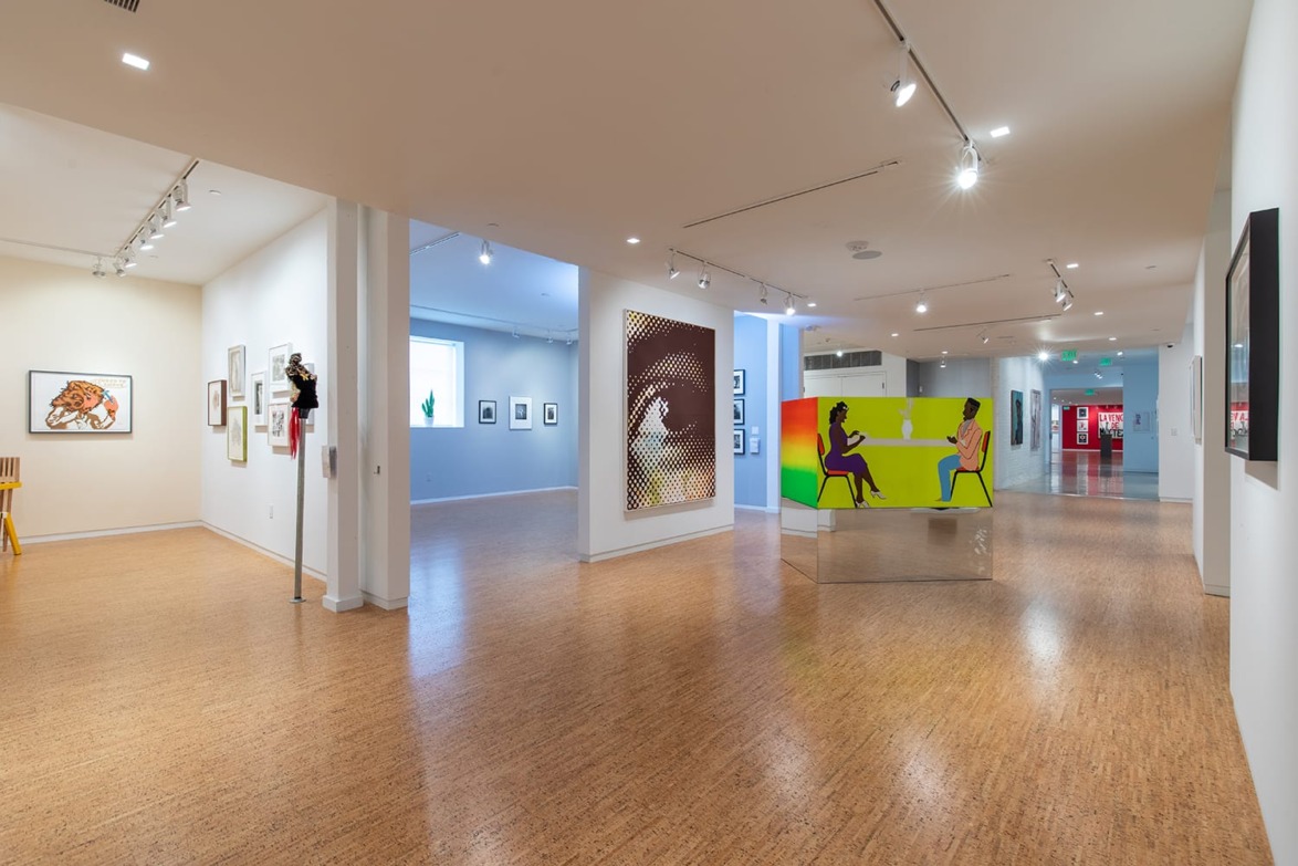Modern art gallery interior with various colorful paintings on walls and bright spacious layout.