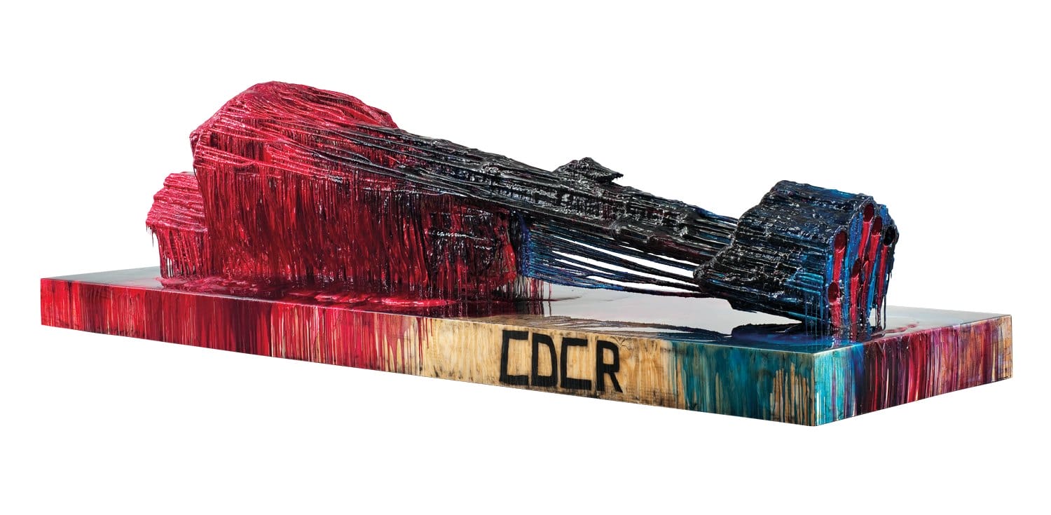 Abstract sculpture featuring red and blue hues on a rectangular base with the text "CCR" visible in black.