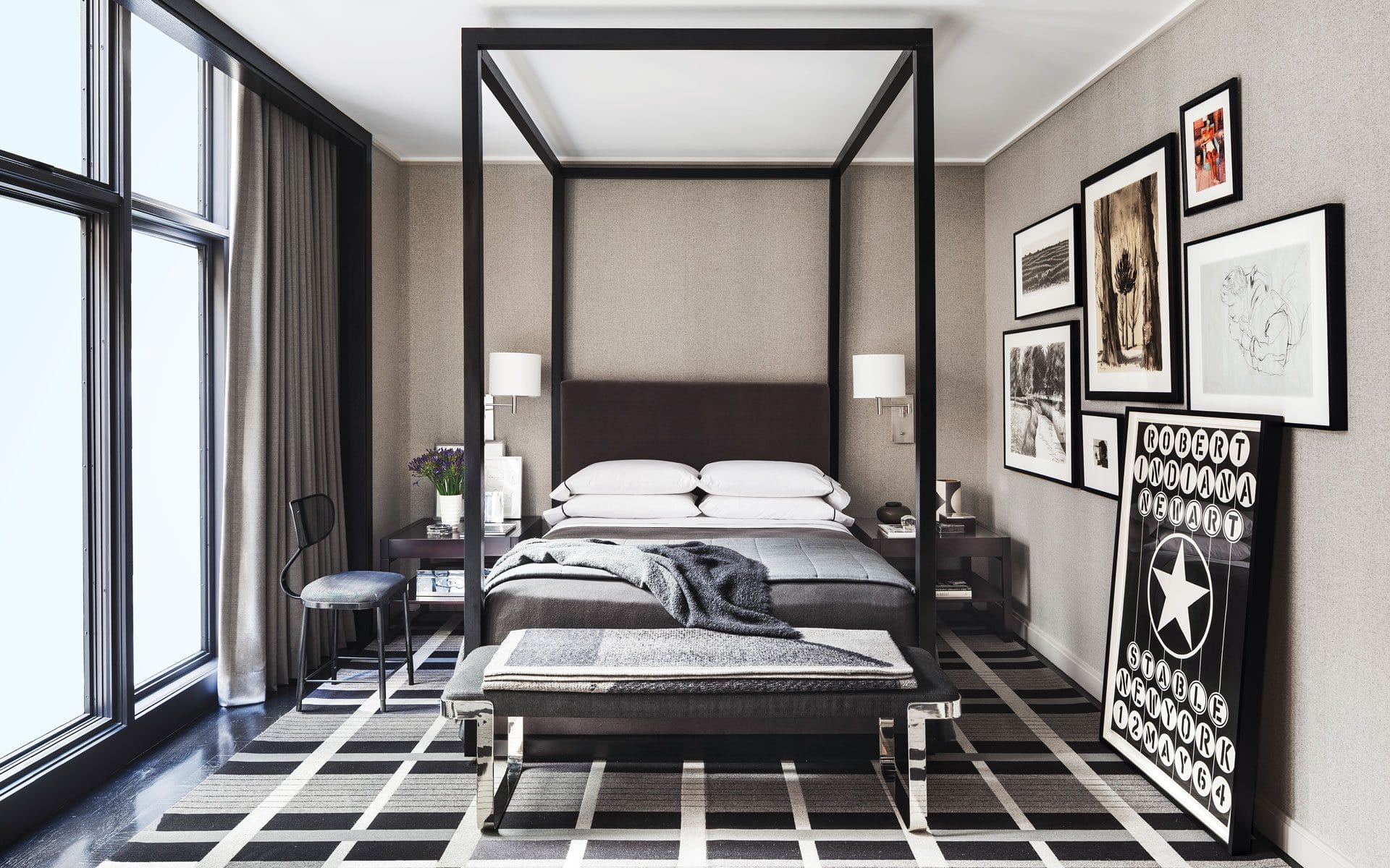 Elegant modern bedroom with a four-poster bed, stylish artwork on walls, large windows, and patterned rug.