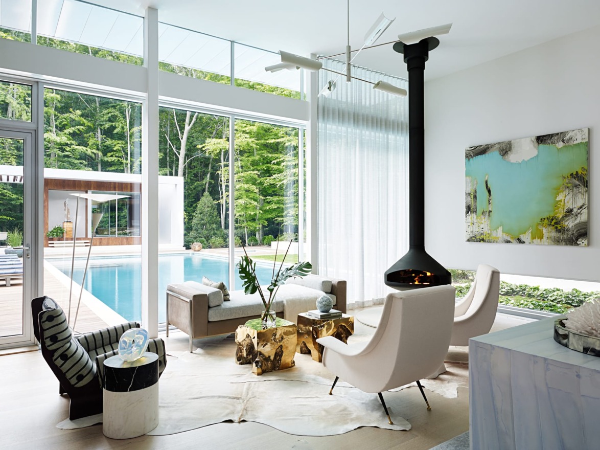The section of the living room that faces the pool and the free-standing poolhouse, designed by Blaze Makoid Architecture, is meant for more intimate gatherings. The rotating fireplace is from Focus.