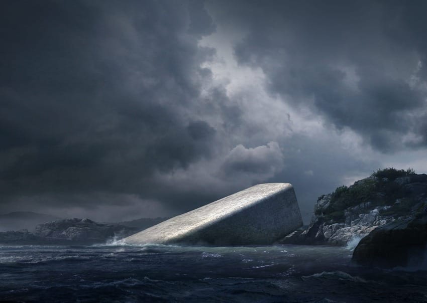 Submerged structure resembling a tilted concrete block in the ocean under a stormy sky near rocky coastlines.