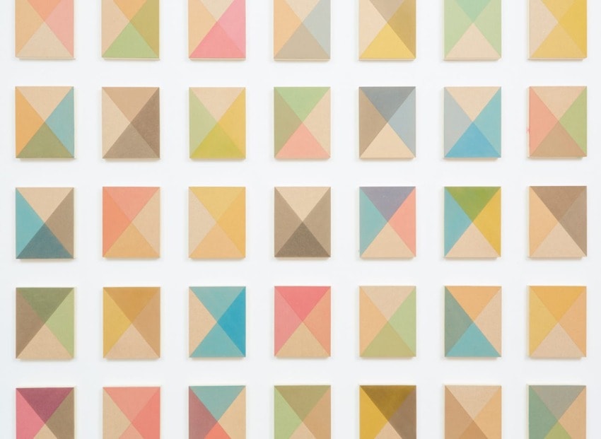 Grid of colorful geometric squares with various pastel patterns on a white background