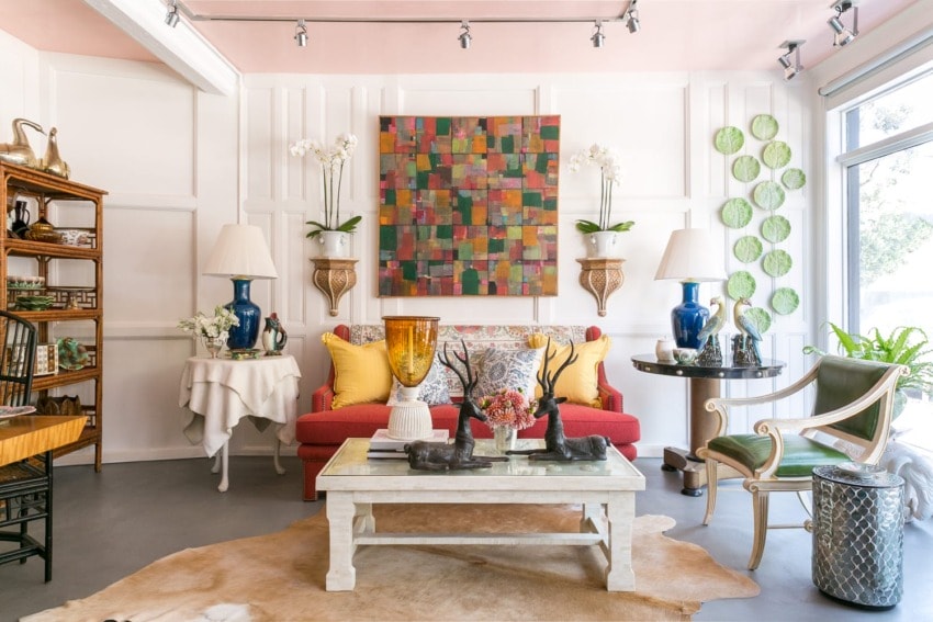 A vibrant living room with colorful abstract art, eclectic decor, and a mix of modern and vintage furniture.