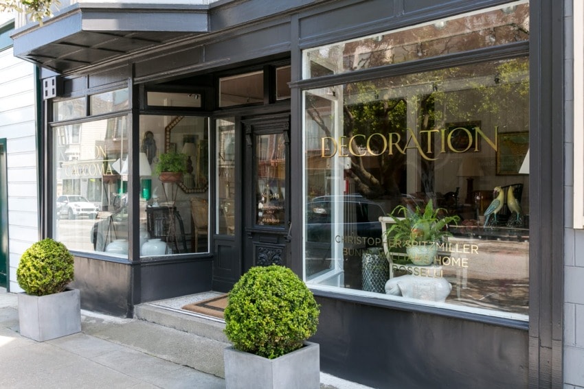 Exterior view of a boutique store with large windows, potted plants, and "Decoration" written on the glass.