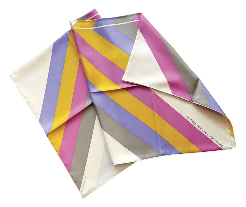 Colorful silk scarf with diagonal stripes in pink, purple, yellow, gray, and cream, artist signature on bottom edge.