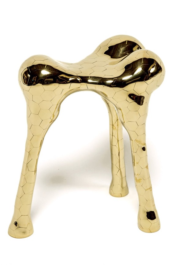 Gold metallic stool with a unique abstract design and textured surface.