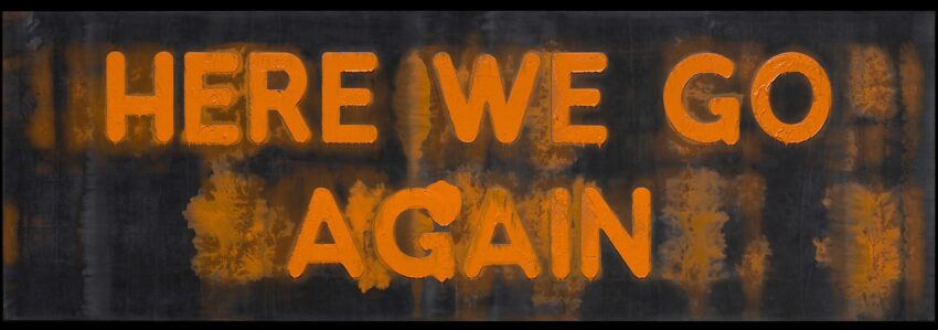 Text on a weathered surface reading "HERE WE GO AGAIN" in orange letters against a dark background.