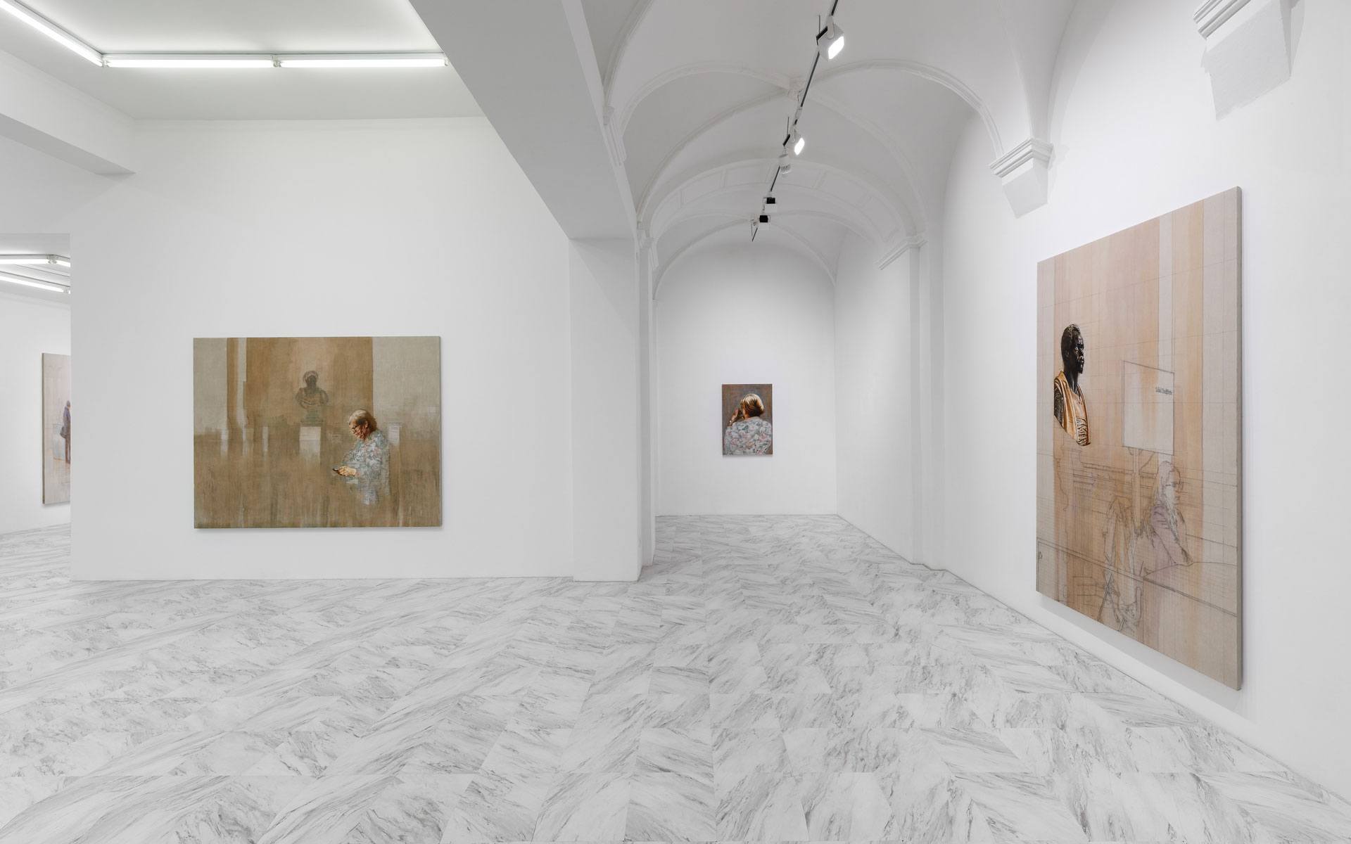 Art gallery with paintings on a white wall, featuring abstract and figurative works, and a white marble floor.