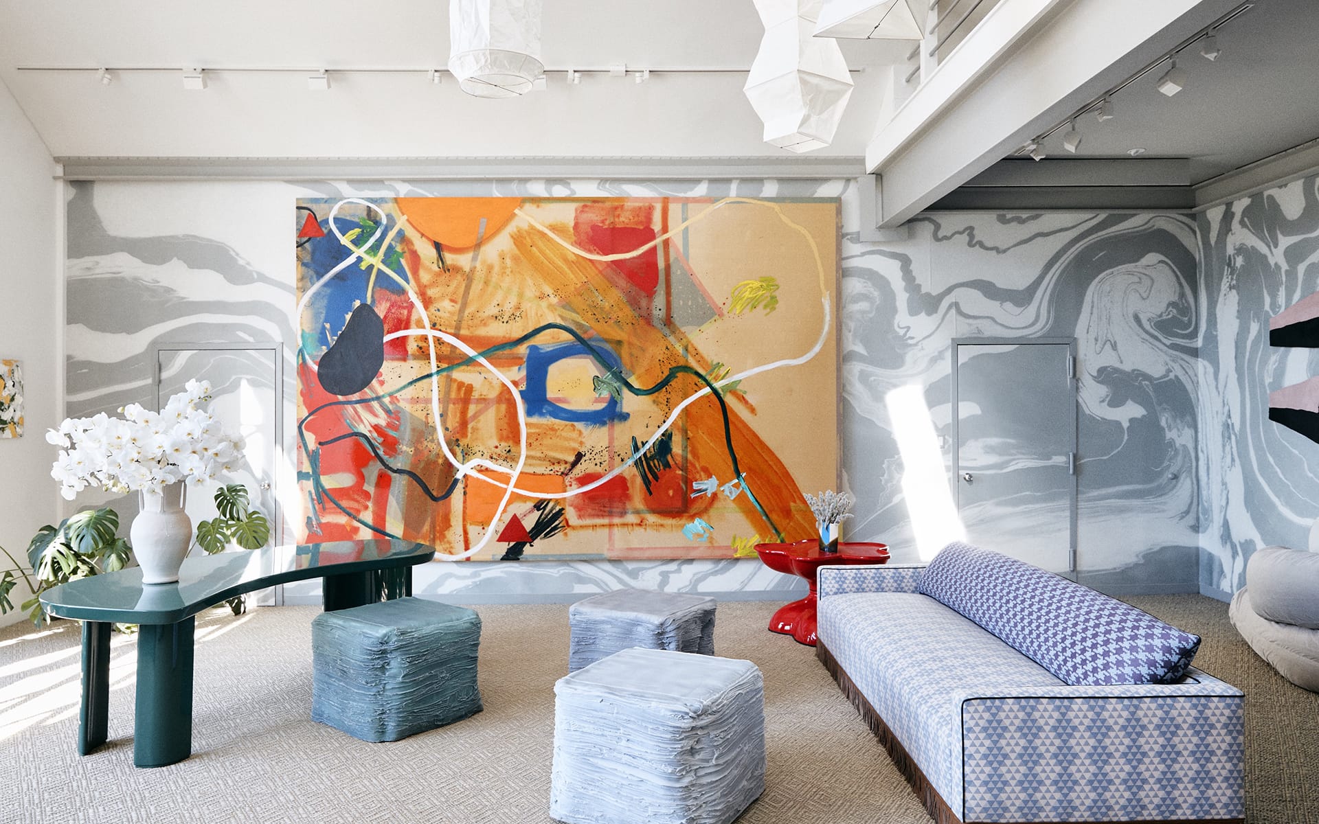 Modern living room with abstract art, patterned furniture, and contemporary decor elements.