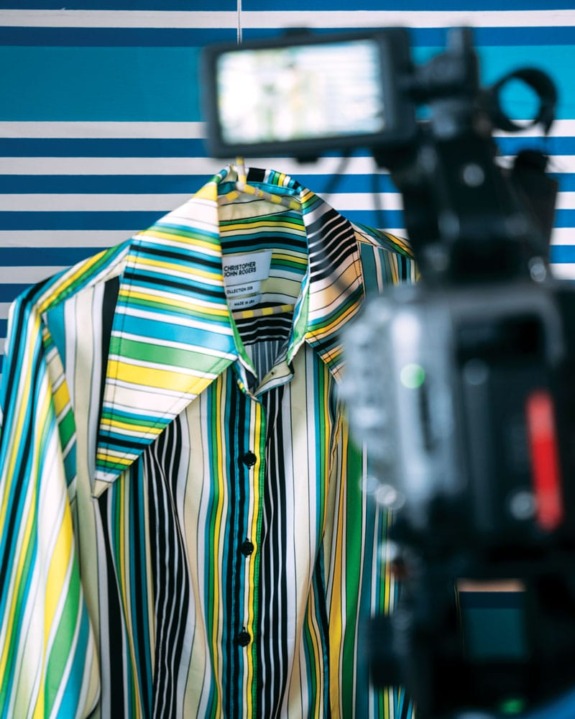Striped shirt hanging, with a video camera in the foreground.