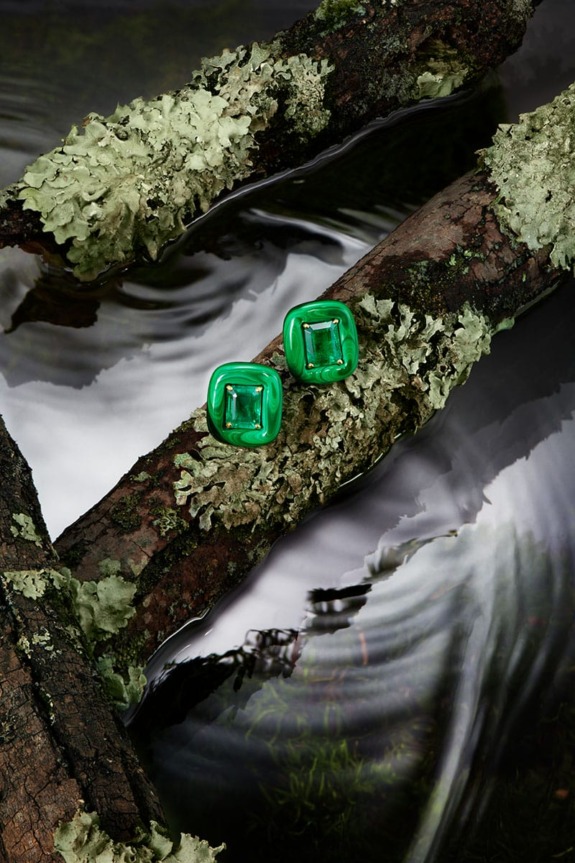Green earrings on lichen-covered branches over flowing water, capturing nature and elegance.
