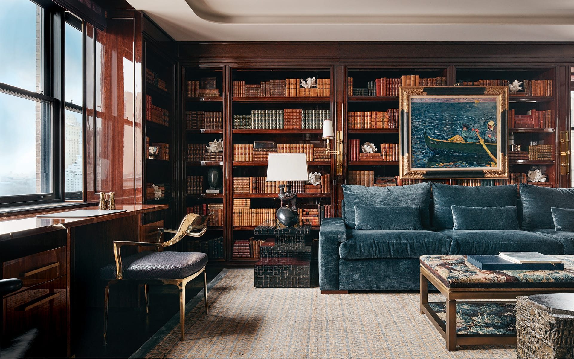 Vintage books are layered with artworks, including a Louis Valtat painting and a selection of Matthew Solomon sculptures, in the library of a Fifth Avenue home designed by interior experts Pembrooke & Ives.