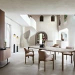 Modern dining room with minimalist decor, spiral staircase, wooden table, beige chairs, and ambient lighting.