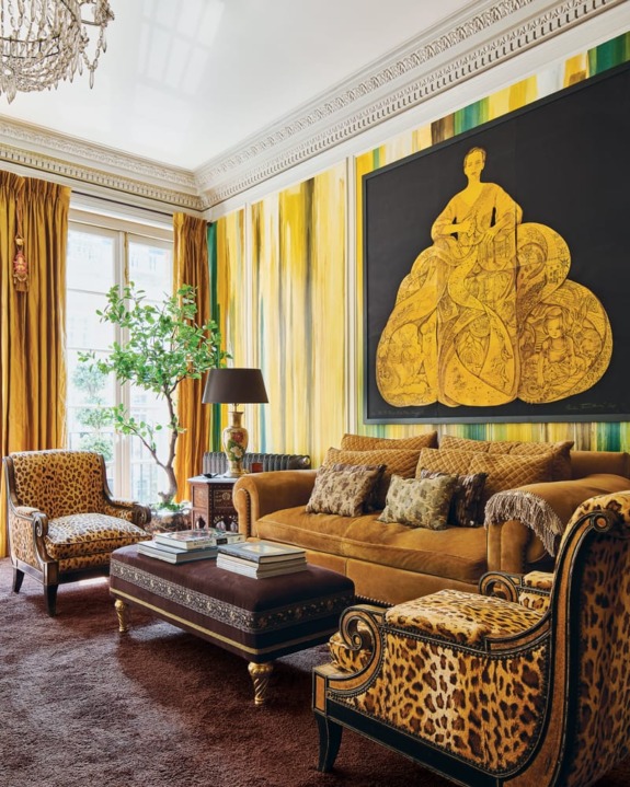 Luxurious living room with gold accents, large decorative painting, leopard-patterned furniture, and a plush brown carpet.