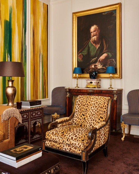 Elegant living room with a leopard print armchair, portrait painting, and vibrant yellow abstract art on the walls.