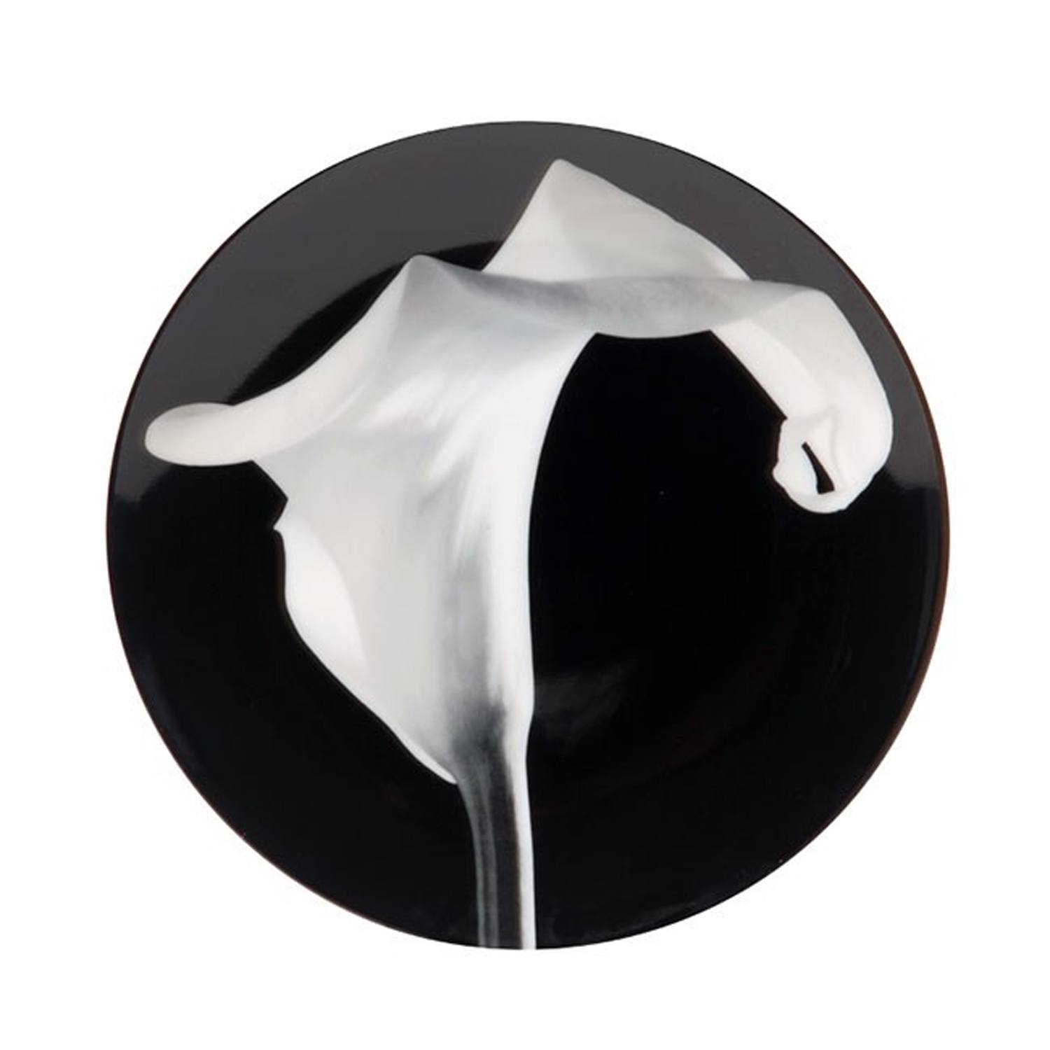 Black plate with elegant white calla lily design in the center.