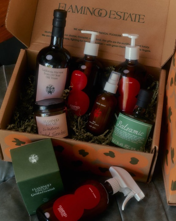Assorted Flamingo Estate products in an open box, featuring oils and skincare items arranged neatly on a soft surface.