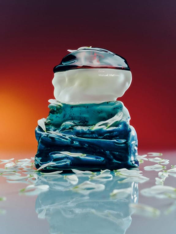 Colorful sculptural creation with abstract shapes, featuring layers of vibrant blue, white, and black against a warm backdrop.