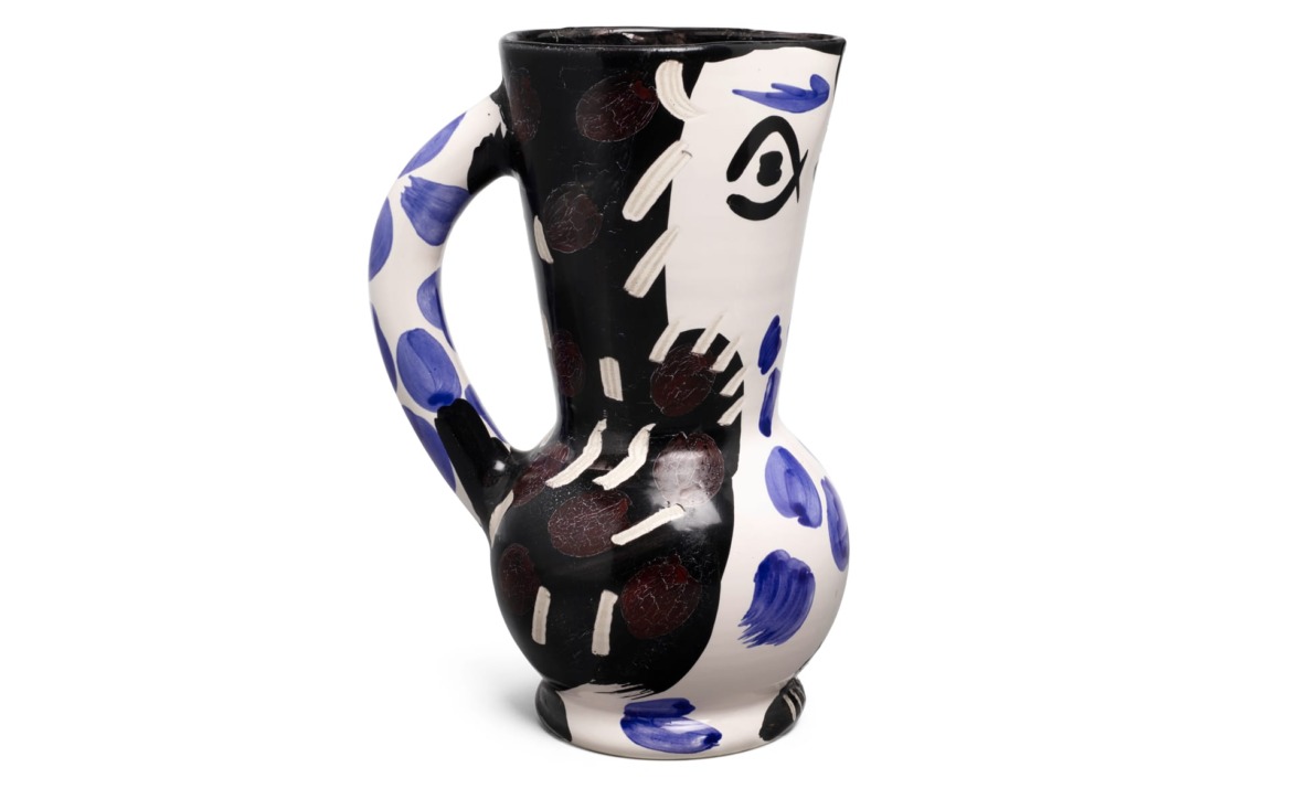 Ceramic jug with abstract black, white, and blue design featuring bold patterns and unique shape.
