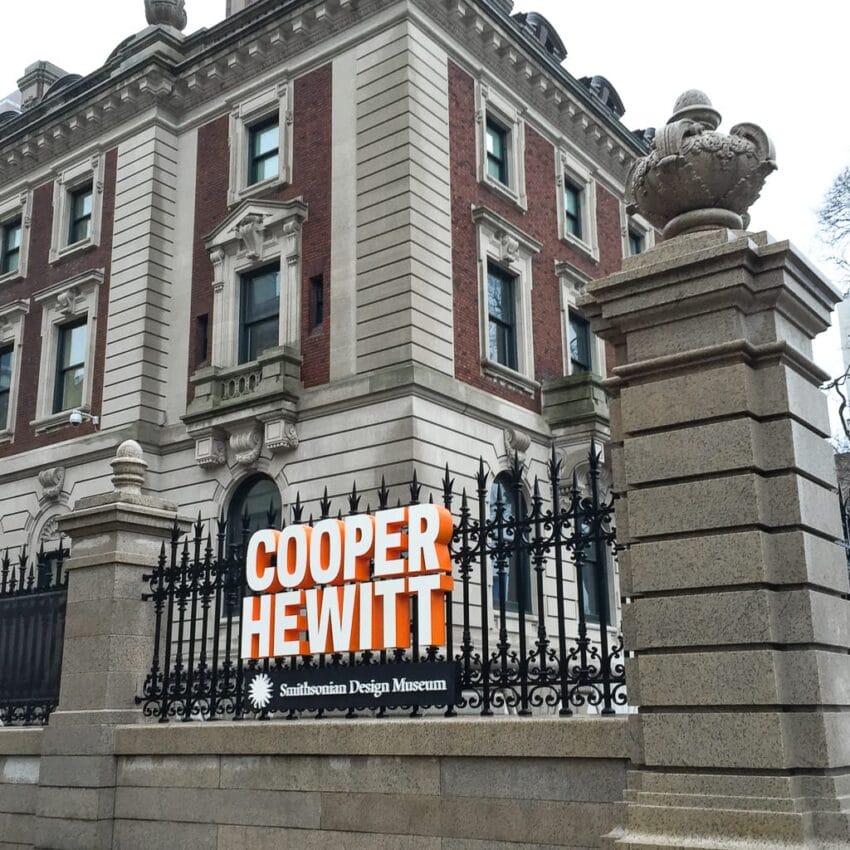 Entrance of Cooper Hewitt Smithsonian Design Museum, featuring a historic building with iron fencing and a large sign.
