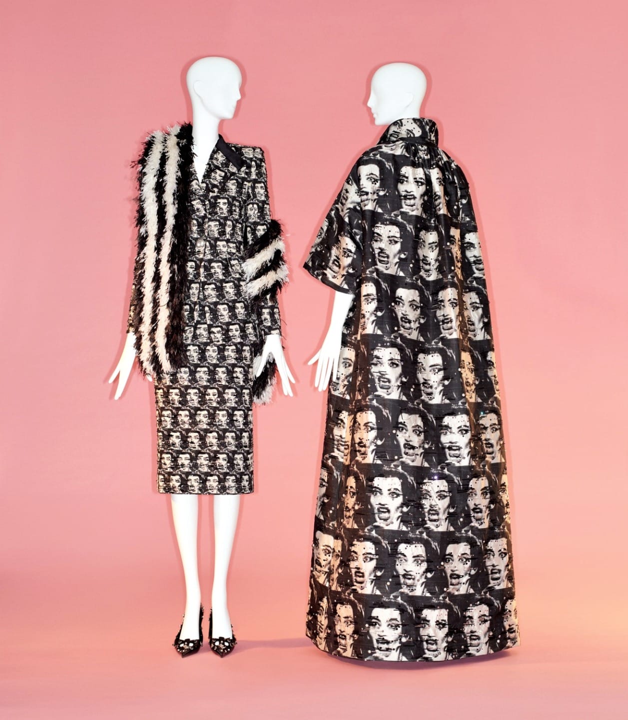 Two mannequins wearing bold black-and-white graphic print outfits on a pink background.