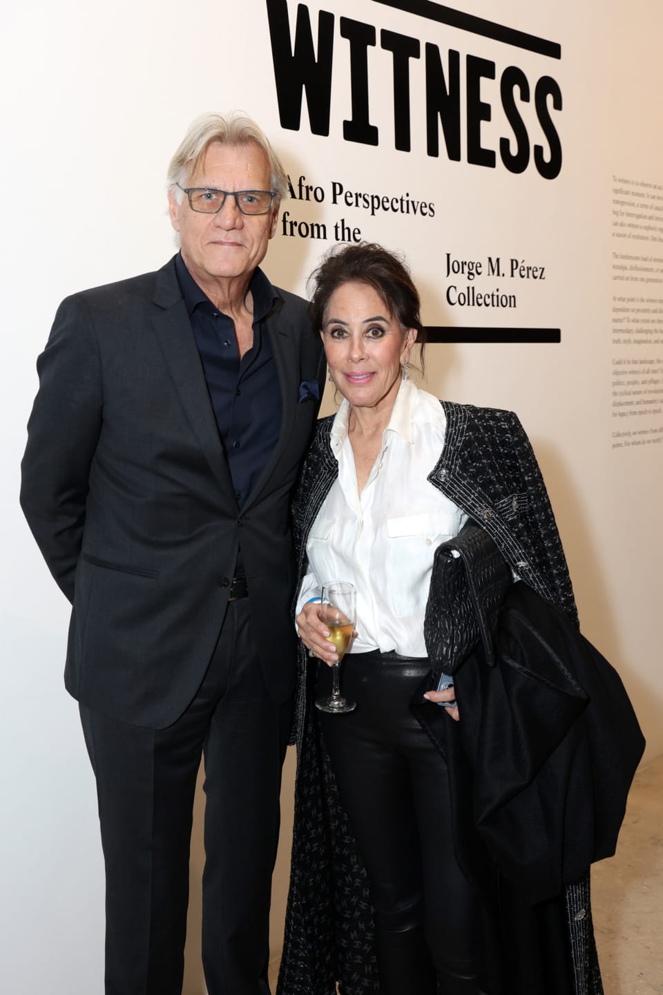 Two people standing in front of an art exhibit titled "Witness: Afro Perspectives from the Jorge M. Pérez Collection"