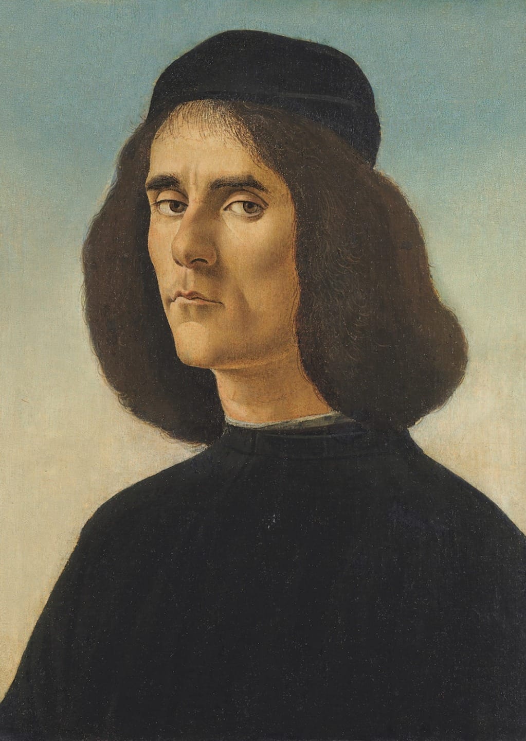 Portrait of a man with long dark hair and a black hat, wearing a black robe, against a neutral background.