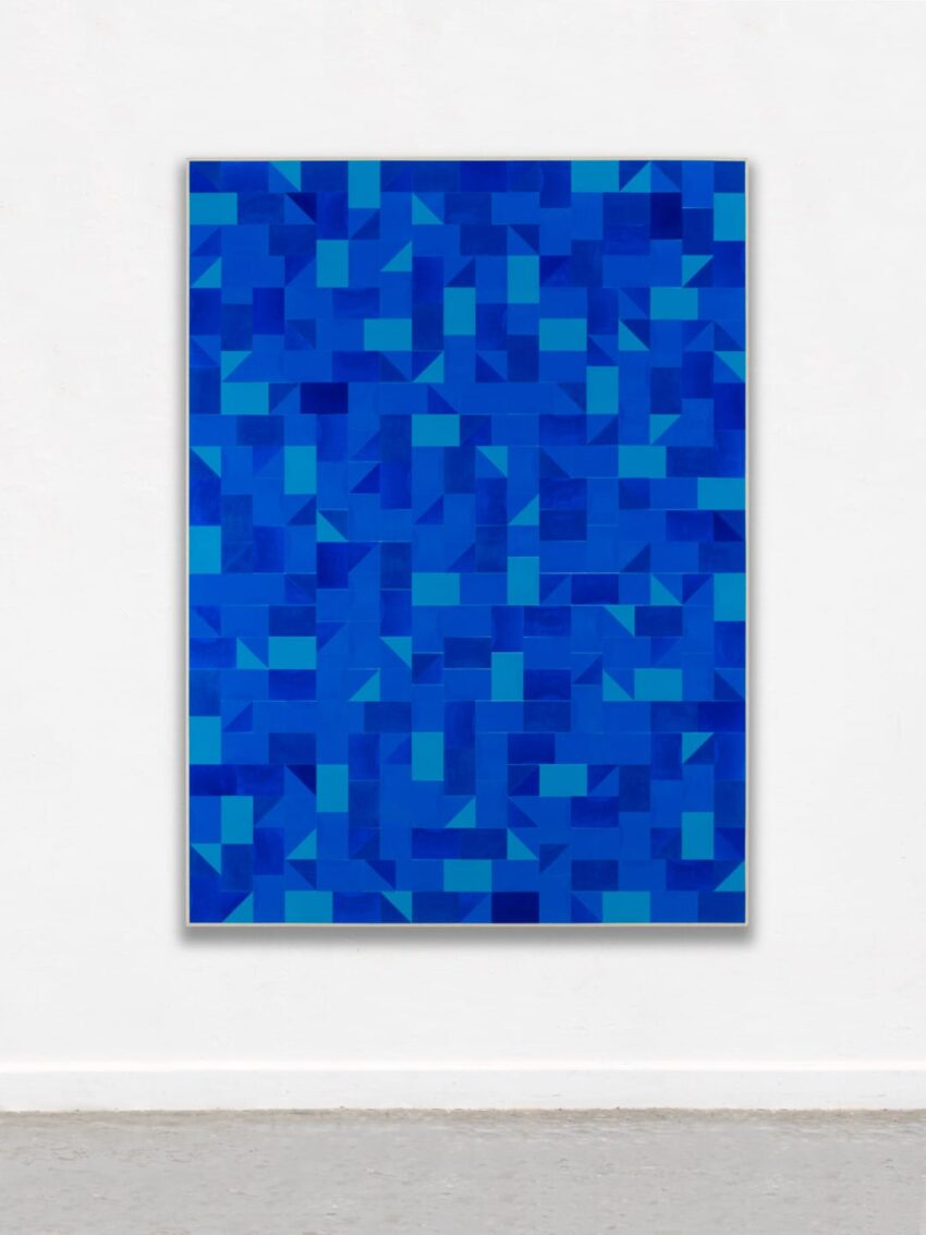 Abstract geometric painting with a pattern of blue and turquoise squares and rectangles on a white gallery wall.