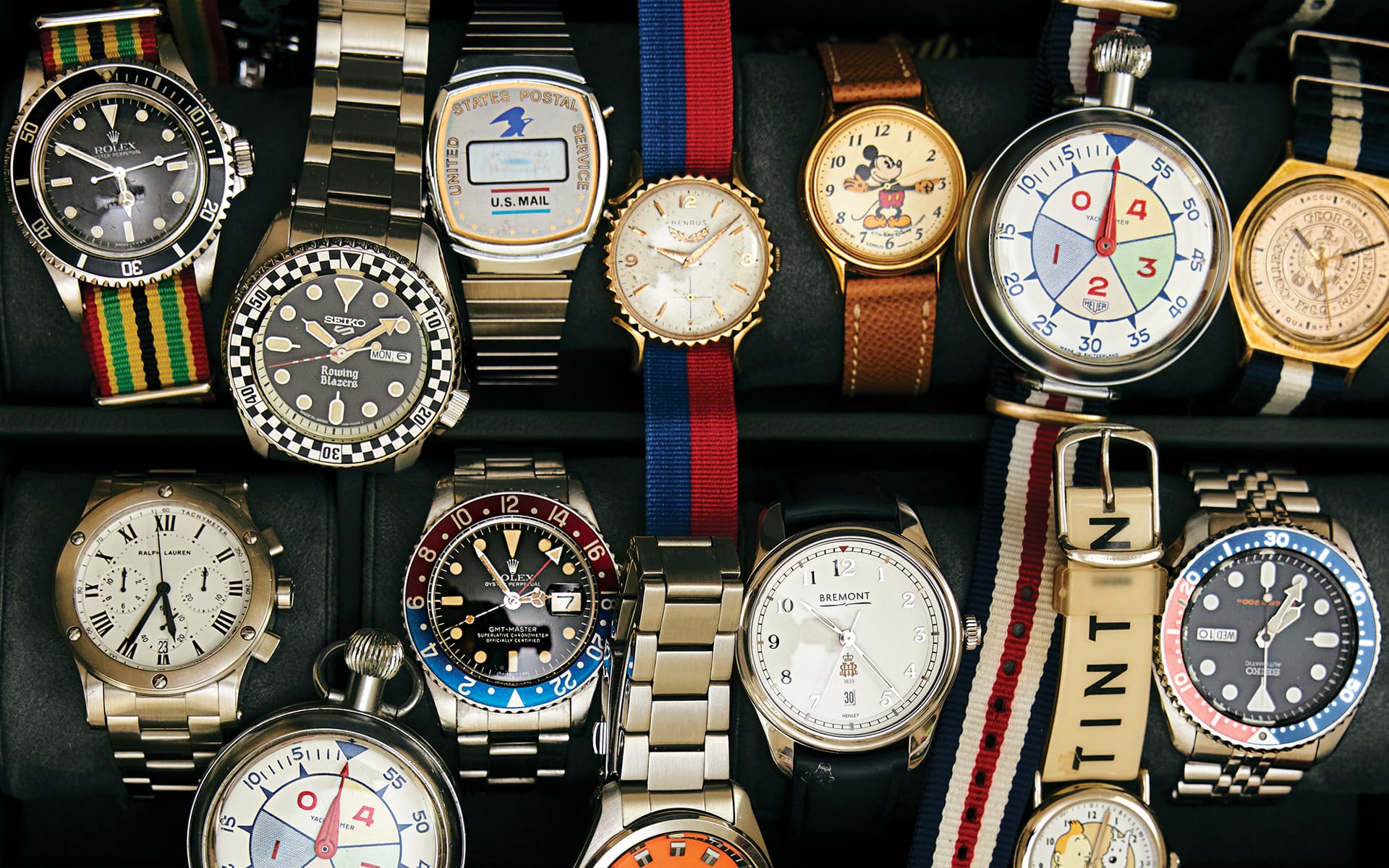 A collection of various wristwatches with different designs, colors, and straps displayed in a neat arrangement.