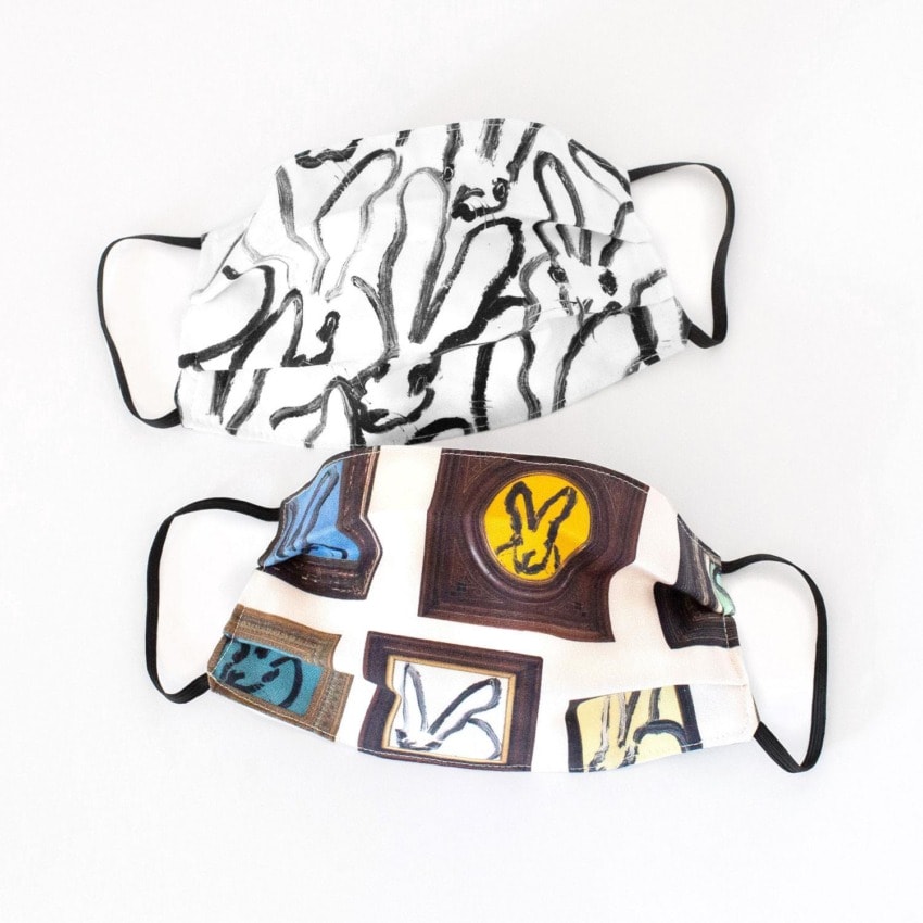 Two fabric face masks with abstract prints, one black and white, the other with colorful graphic designs, on a white background.