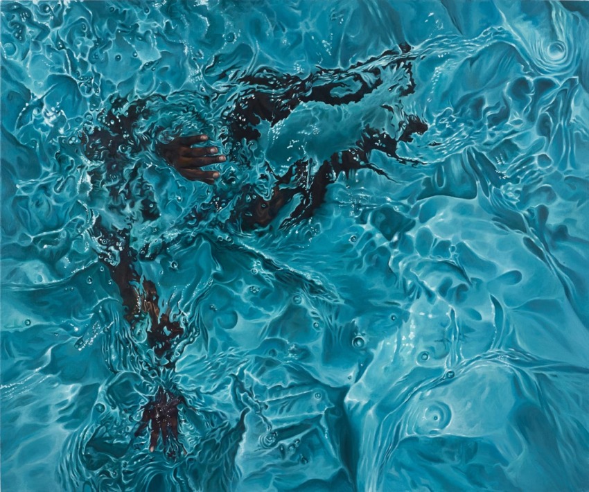 Aerial view of a person swimming in clear blue water, with ripples and waves creating abstract patterns around them.