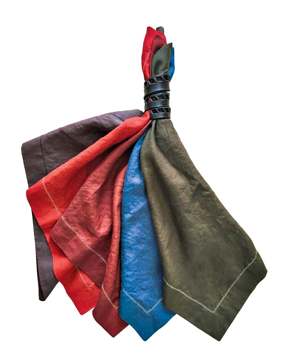 Colorful fabric napkins in brown, red, blue, and green, elegantly folded and secured with a black decorative napkin holder.