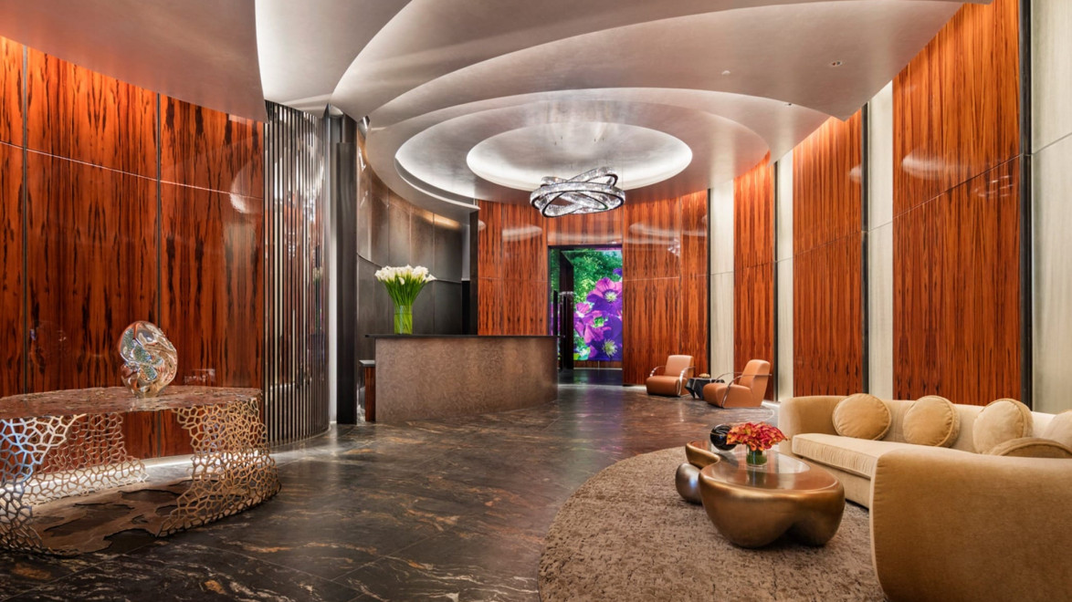 Luxurious lobby with modern decor, plush seating, and artistic lighting, featuring a natural wood and marble design.
