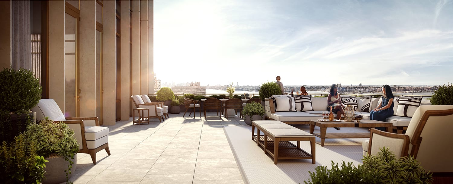 Rooftop terrace with seating area, plants, and people enjoying the sunlight overlooking a cityscape in the distance.