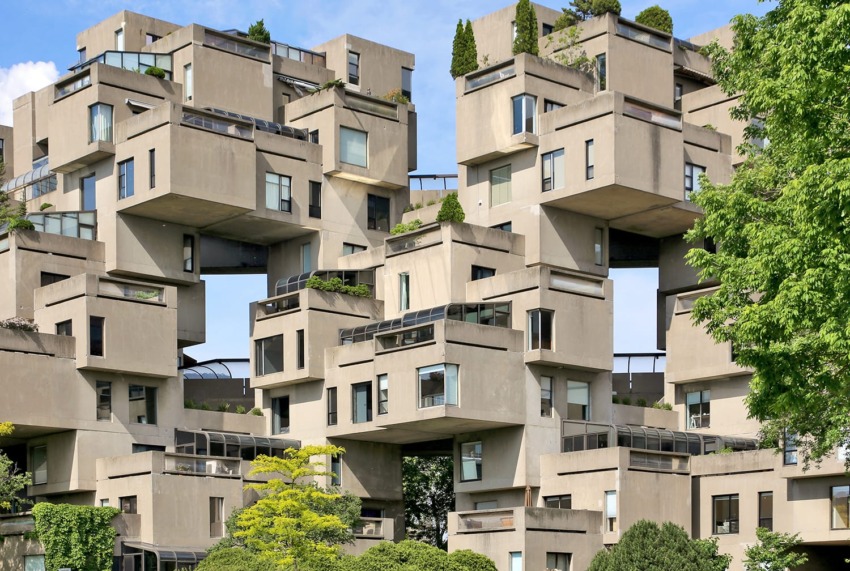 Brutalist architecture of Habitat 67 in Montreal, featuring modular concrete units with greenery and terraces.
