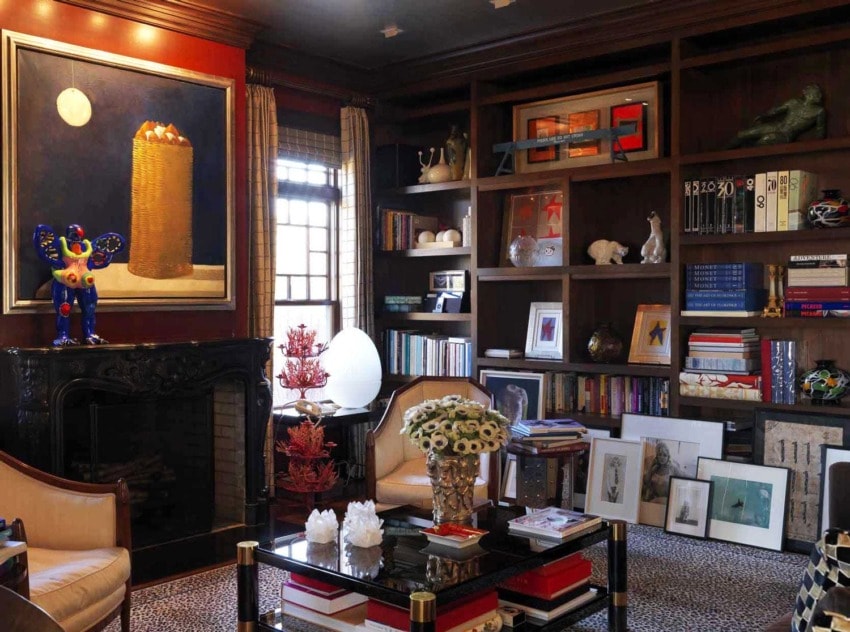 Colorful living room with art, bookshelves, and decor, including a bold painting, sculptures, and a cozy seating area.