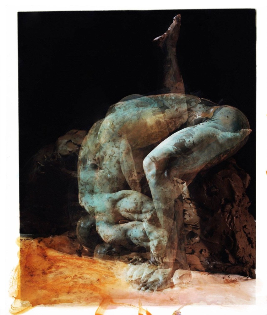 Abstract sculpture of a human figure in a dynamic pose, with layered textures and earthy tones on a dark background.